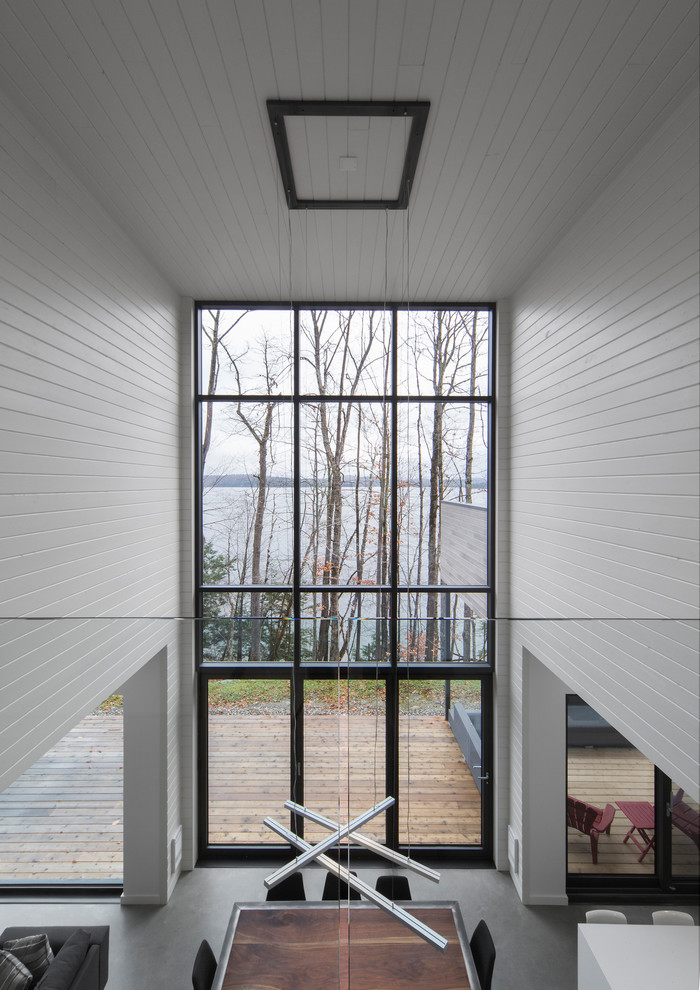 Источник вдохновения для домашнего уюта: большой коридор в современном стиле с белыми стенами и бетонным полом