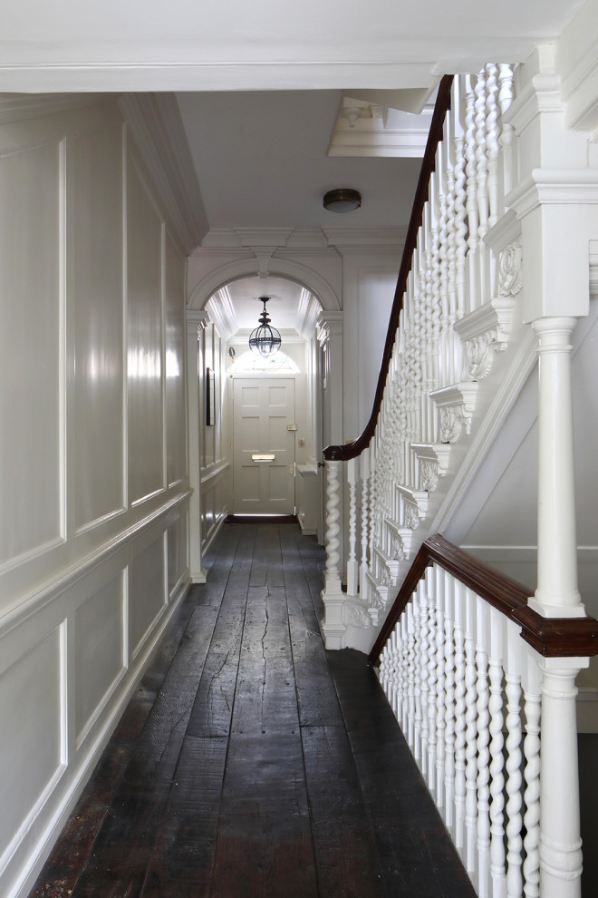 Idée de décoration pour un couloir tradition de taille moyenne avec un mur blanc, parquet peint et un sol marron.