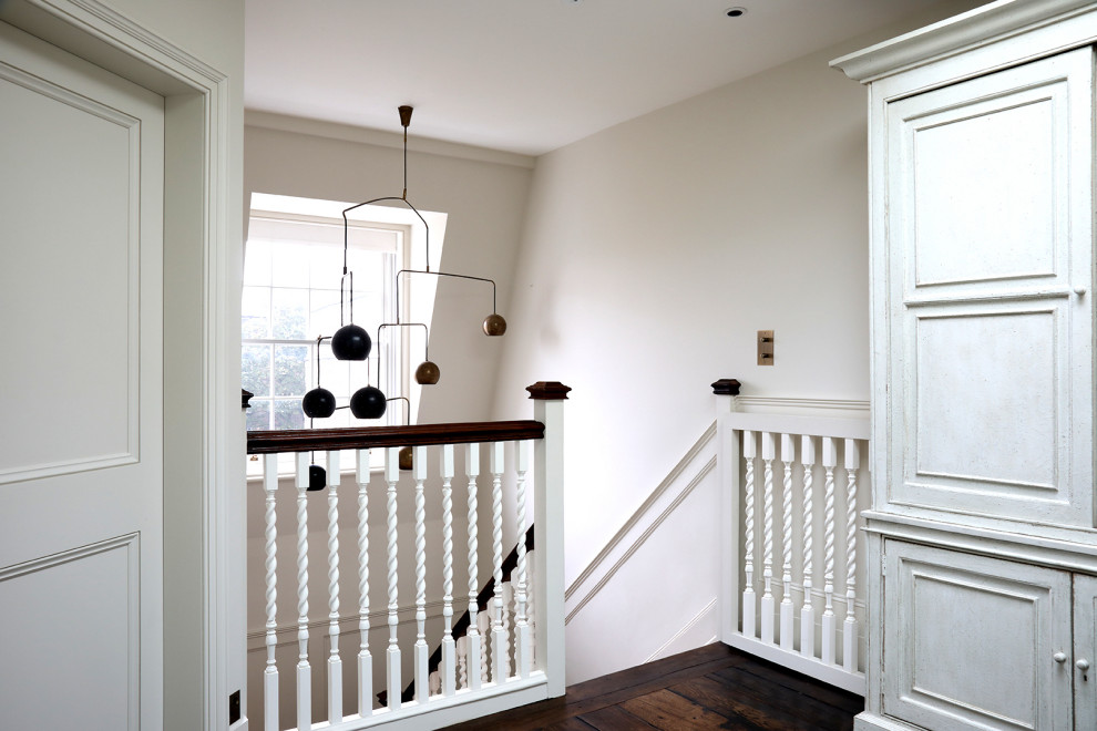 Idées déco pour un couloir classique de taille moyenne avec un mur blanc, parquet peint et un sol marron.