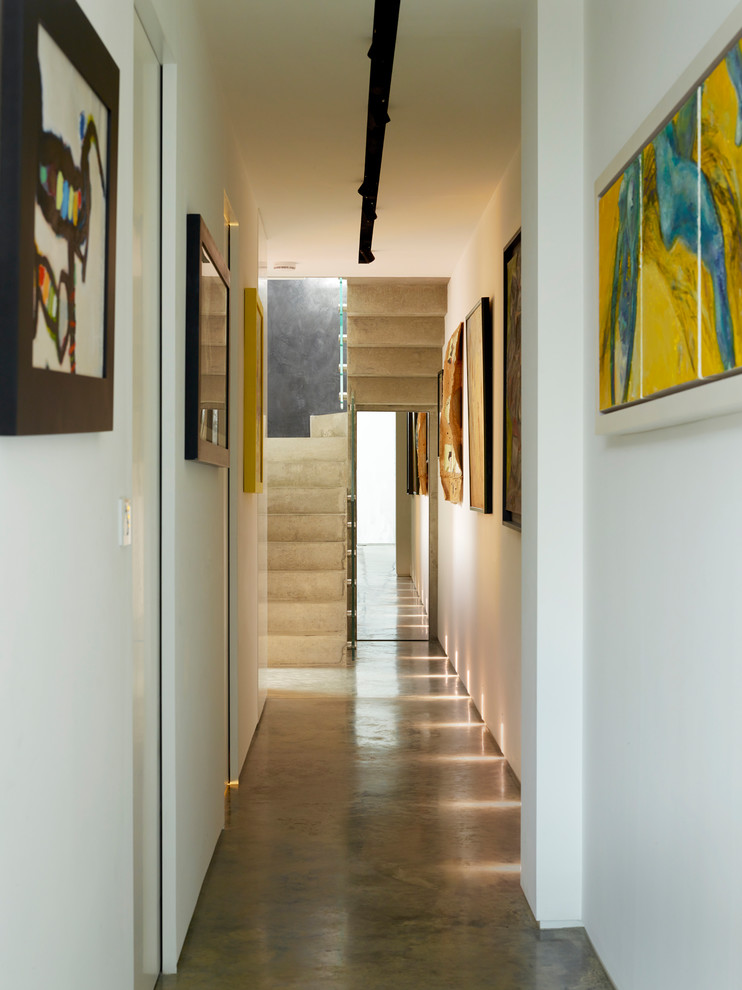 Пример оригинального дизайна: огромный коридор в современном стиле с желтыми стенами, бетонным полом и серым полом