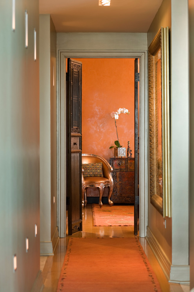 Idées déco pour un petit couloir contemporain avec un mur vert, parquet clair et un sol orange.
