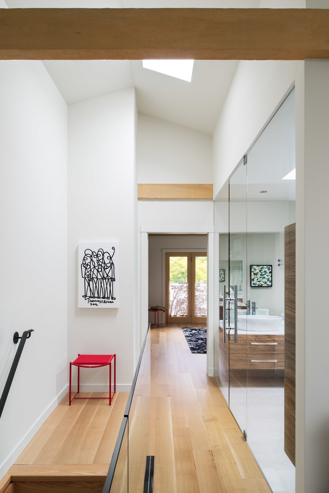 Стильный дизайн: коридор в современном стиле с белыми стенами и паркетным полом среднего тона - последний тренд