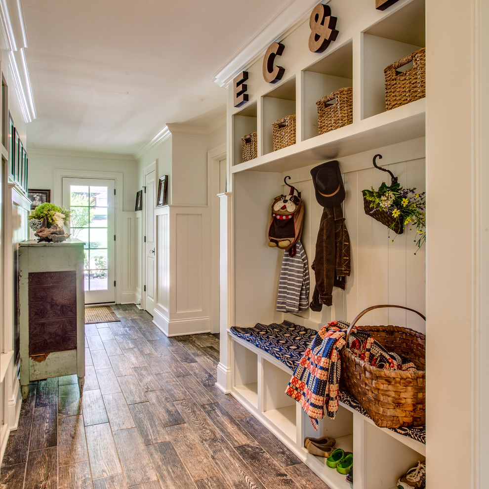 Example of a huge country medium tone wood floor hallway design in Nashville with white walls