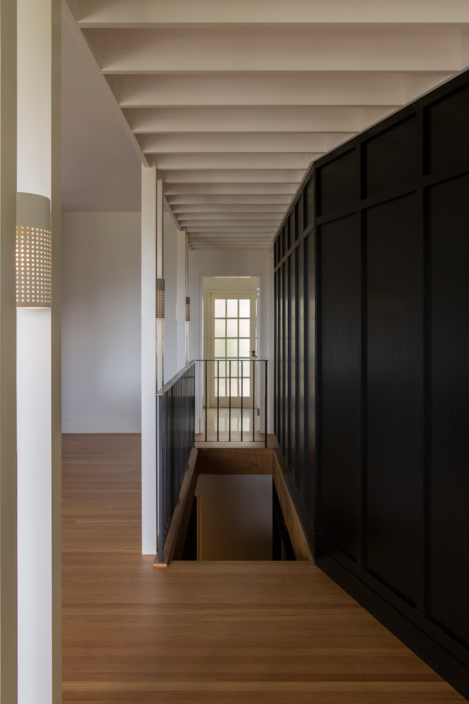 Inspiration pour un couloir design avec un sol en bois brun.