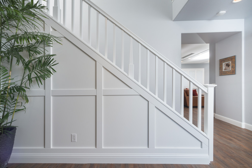 Example of a mid-sized transitional vinyl floor, brown floor and wall paneling hallway design in San Diego with white walls