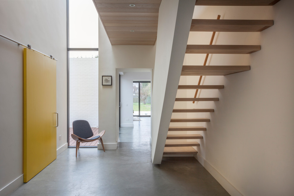Inspiration för mellanstora moderna hallar, med vita väggar, betonggolv och grått golv