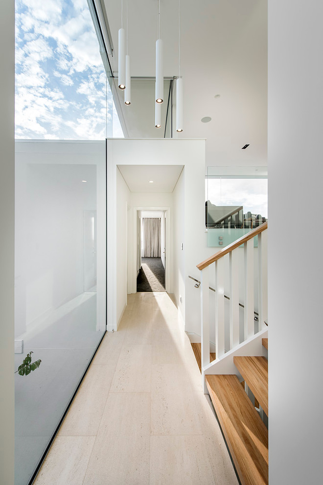 На фото: коридор в стиле модернизм с белыми стенами и полом из травертина