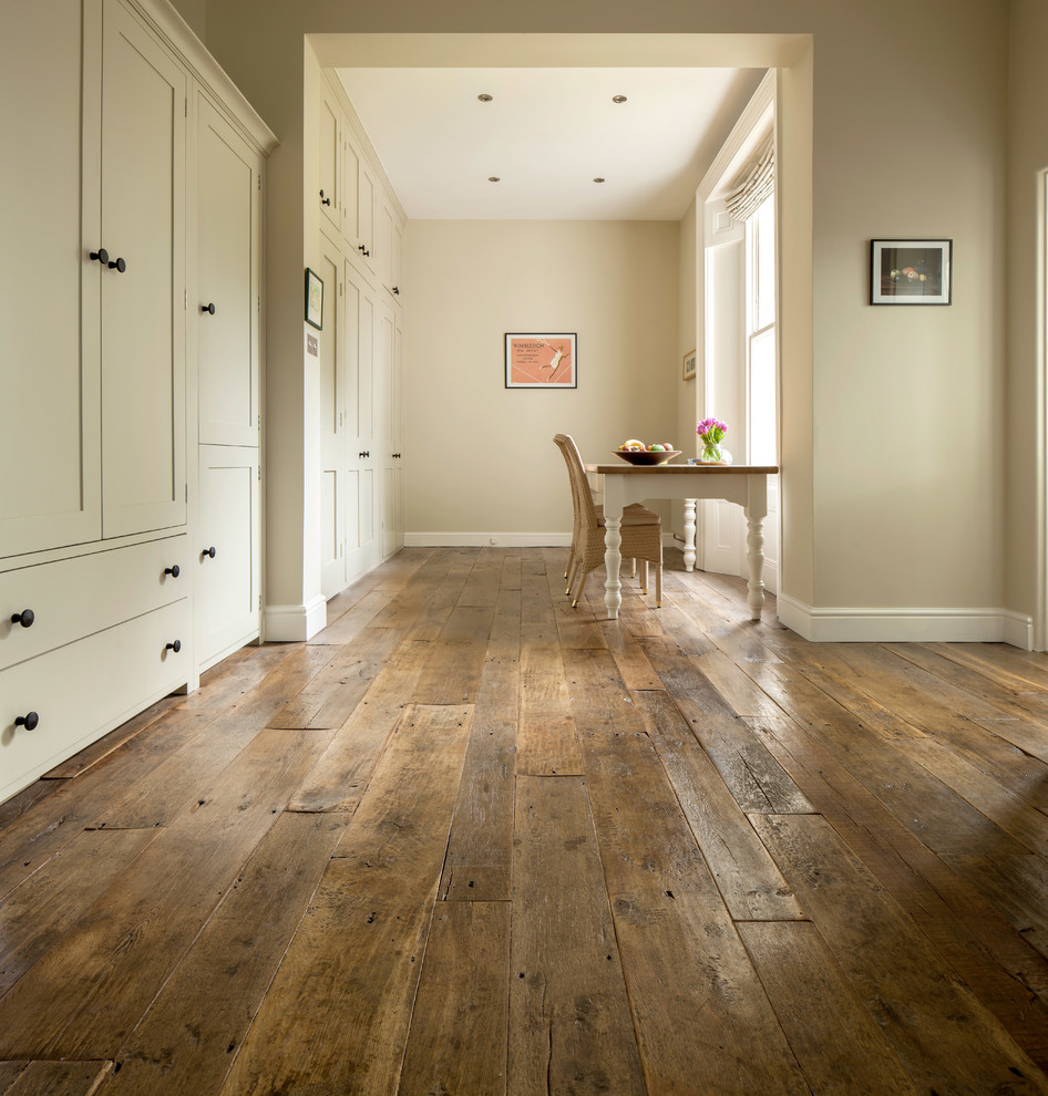 Example of a mid-sized classic medium tone wood floor and brown floor hallway design in Other with beige walls