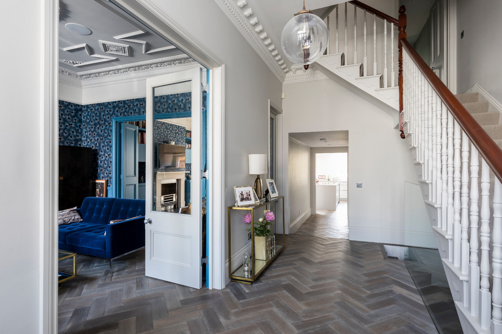 Example of a mid-sized trendy dark wood floor and brown floor hallway design in London with gray walls