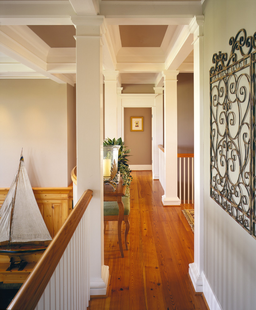 Imagen de recibidores y pasillos clásicos grandes con paredes beige, suelo de madera en tonos medios y casetón