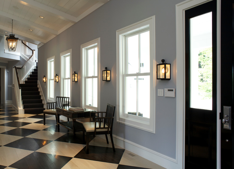 Aménagement d'un grand couloir classique avec un mur gris, parquet clair et un sol multicolore.