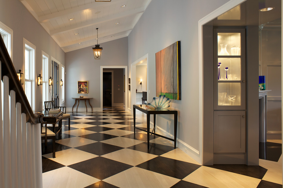 Пример оригинального дизайна: большой коридор в классическом стиле с серыми стенами, светлым паркетным полом и разноцветным полом