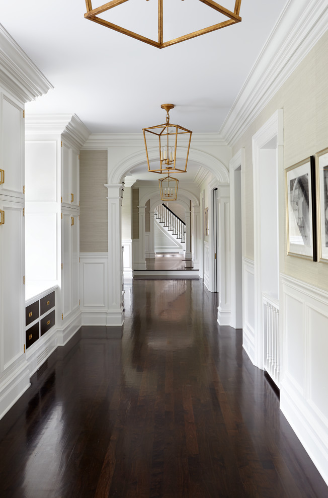 Пример оригинального дизайна: большой коридор в классическом стиле с бежевыми стенами и темным паркетным полом