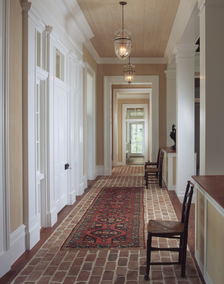 На фото: коридор в классическом стиле с бежевыми стенами и кирпичным полом с