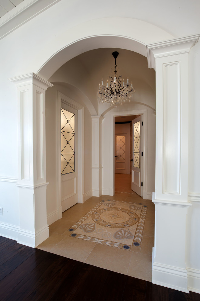 Cette image montre un couloir traditionnel de taille moyenne avec un mur blanc et un sol en travertin.