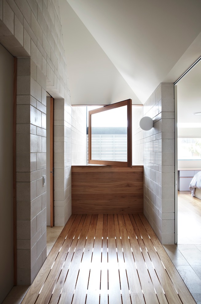 Ejemplo de recibidores y pasillos contemporáneos de tamaño medio con paredes blancas y suelo de madera en tonos medios