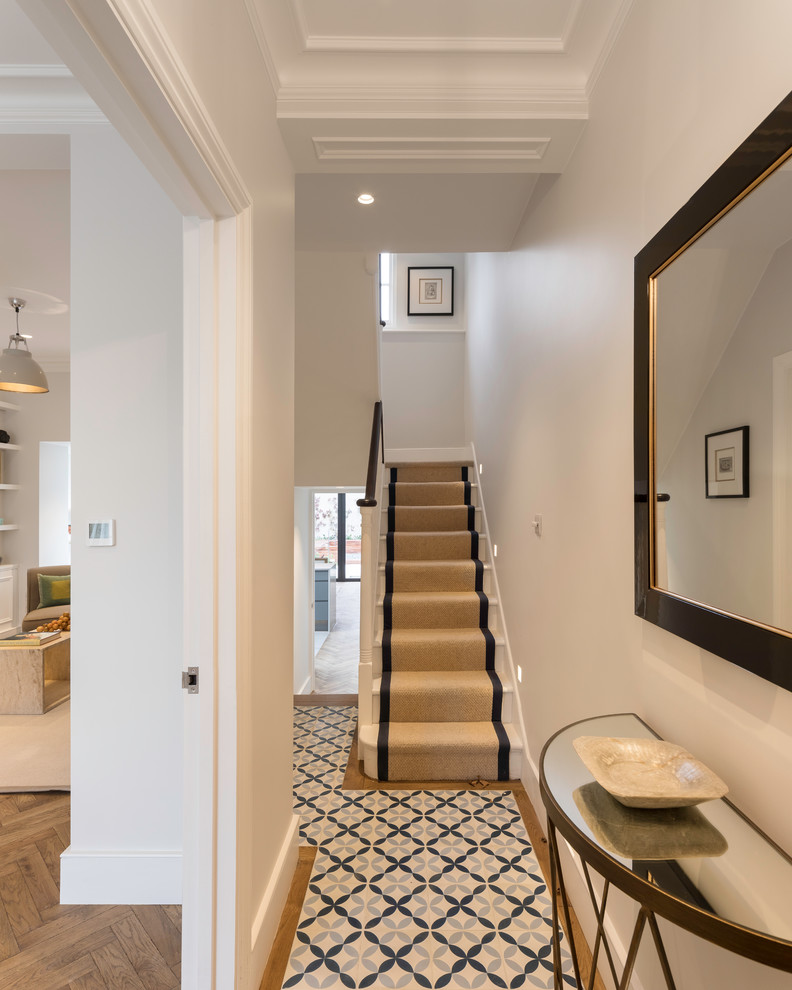 Mid-sized trendy concrete floor and blue floor hallway photo in London with white walls