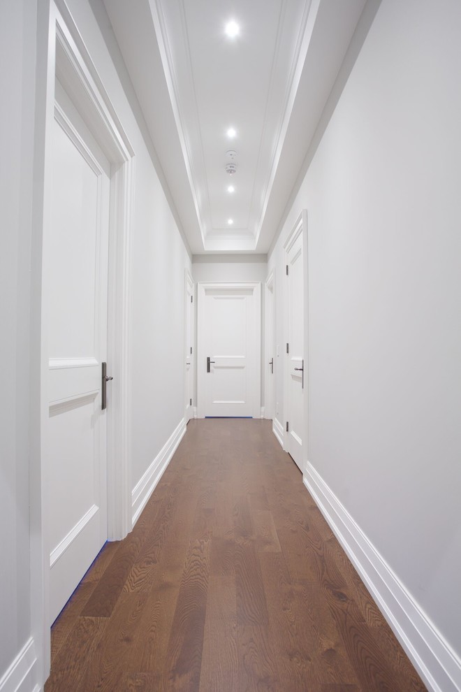 Réalisation d'un couloir tradition de taille moyenne avec un mur gris et parquet foncé.