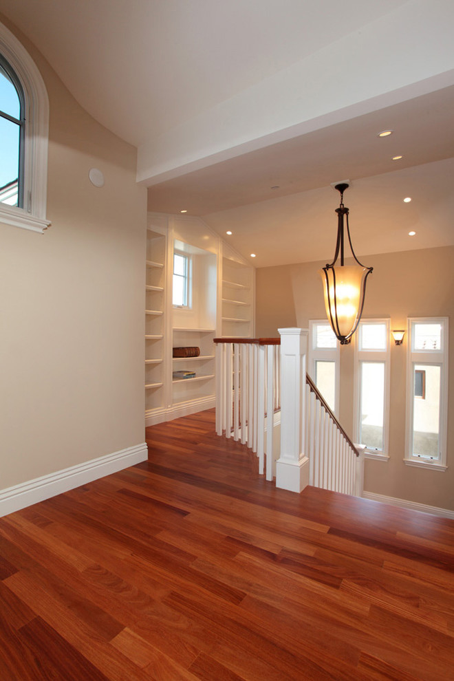 Mid-sized elegant medium tone wood floor hallway photo in Orange County with beige walls