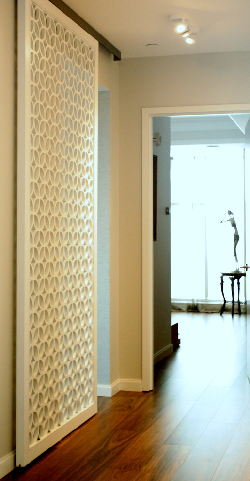 Aménagement d'un grand couloir contemporain avec parquet foncé et un mur gris.