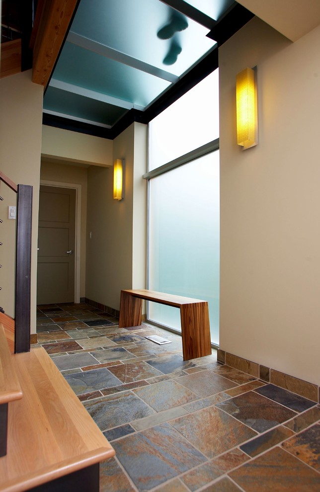 Diseño de recibidores y pasillos actuales de tamaño medio con paredes beige, suelo de pizarra, suelo multicolor y vigas vistas