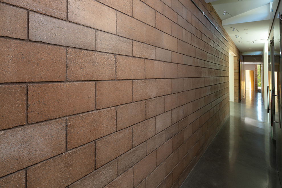 Cette photo montre un couloir tendance de taille moyenne avec un mur beige, sol en béton ciré et un sol gris.