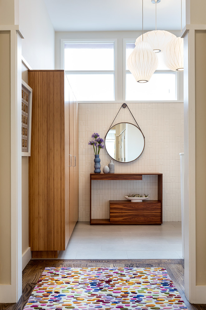 Cette image montre un couloir design avec un mur blanc et un sol en bois brun.