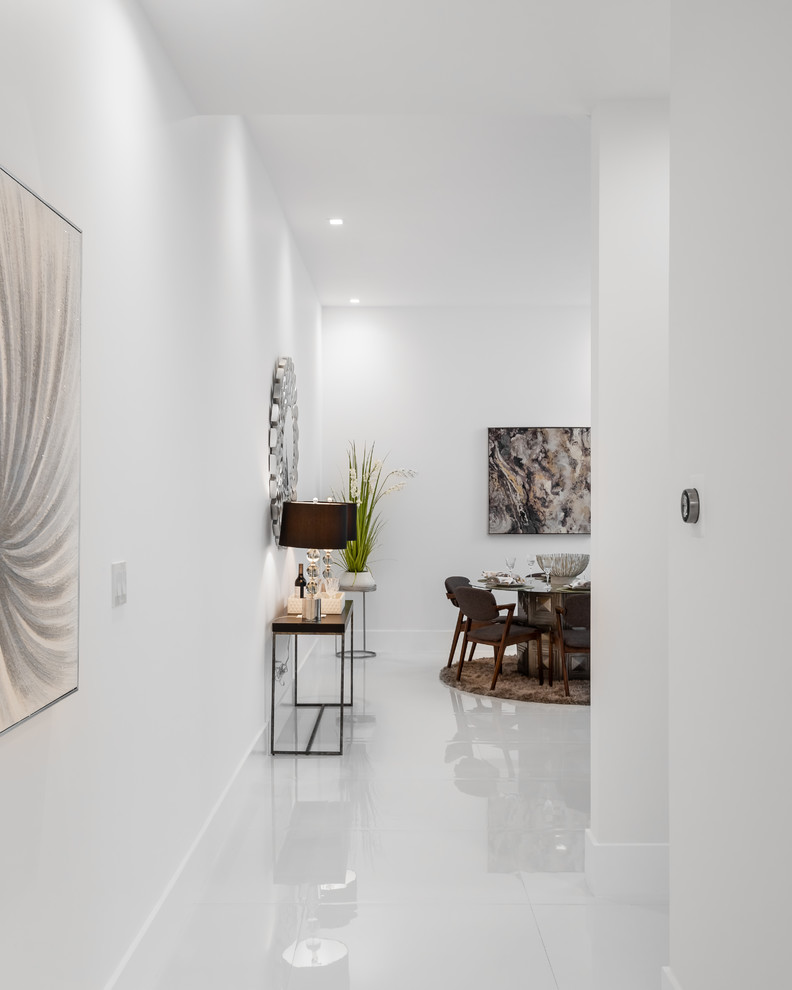 Réalisation d'un couloir minimaliste de taille moyenne avec un mur blanc, un sol en carrelage de céramique et un sol blanc.
