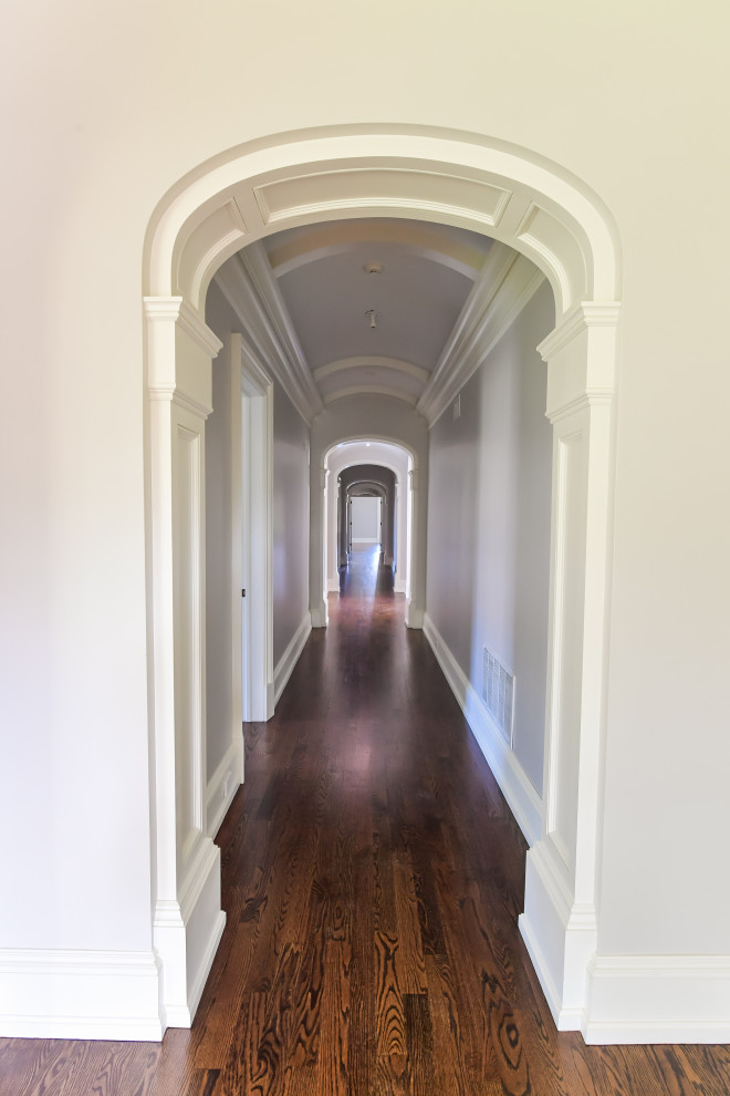 Inspiration for a large timeless dark wood floor and brown floor hallway remodel in New York with gray walls