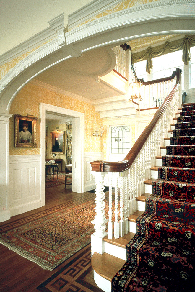 Inspiration for a large timeless medium tone wood floor hallway remodel in Boston with yellow walls
