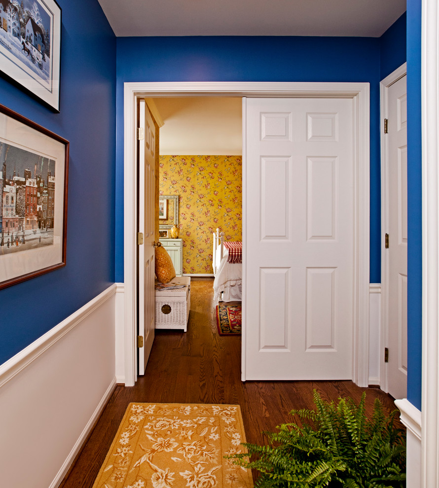 Exemple d'un couloir chic avec un mur bleu et parquet foncé.
