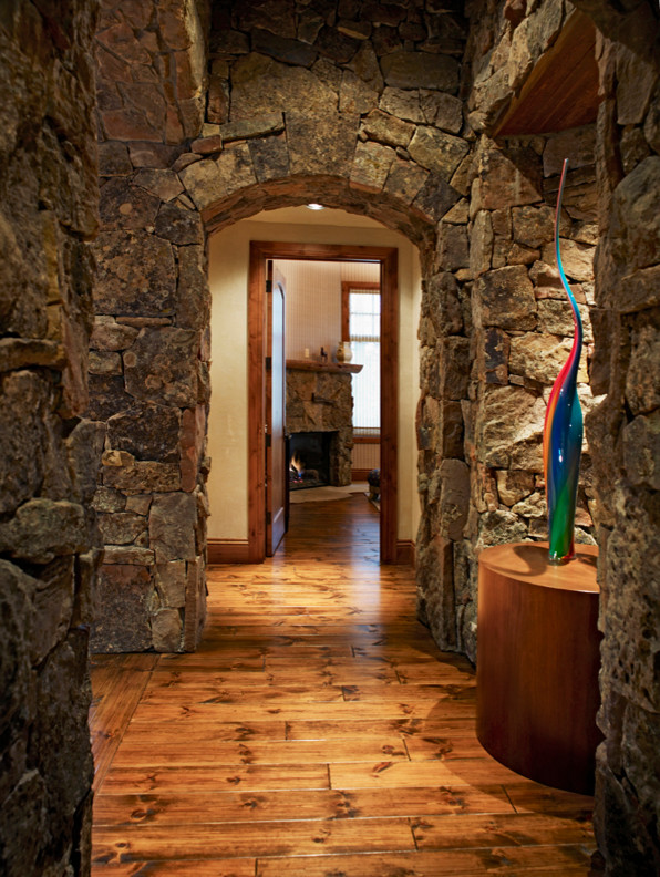 Cette image montre un grand couloir chalet avec un mur marron et un sol en bois brun.