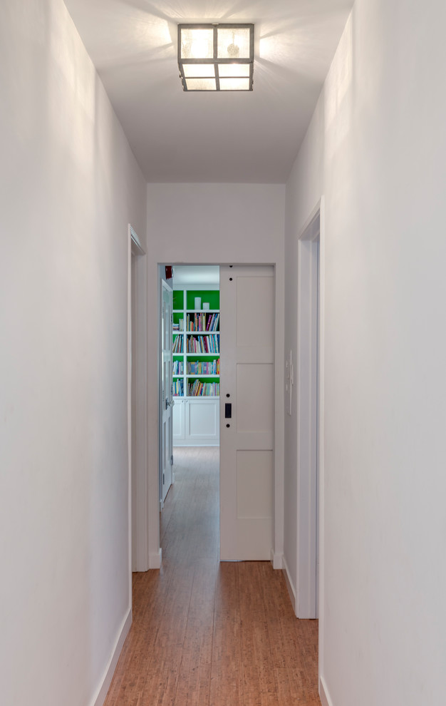 Inspiration pour un petit couloir design avec un mur blanc, un sol en liège et un sol beige.