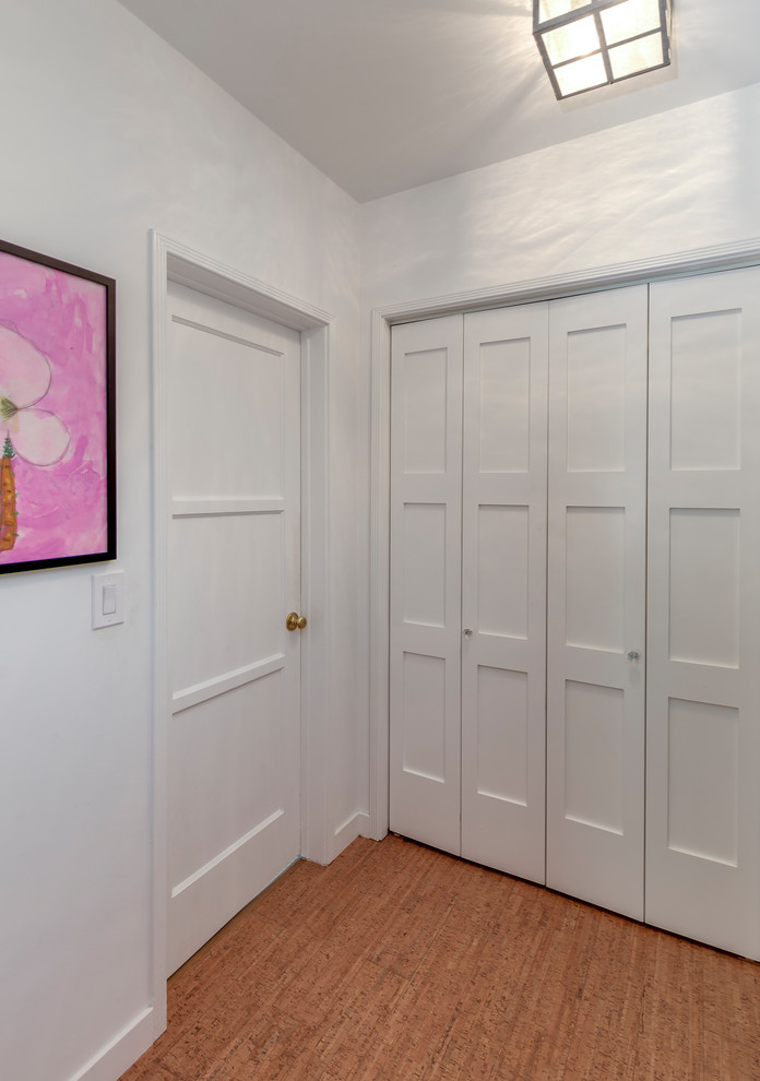 Esempio di un piccolo ingresso o corridoio minimal con pareti bianche, pavimento in sughero e pavimento beige