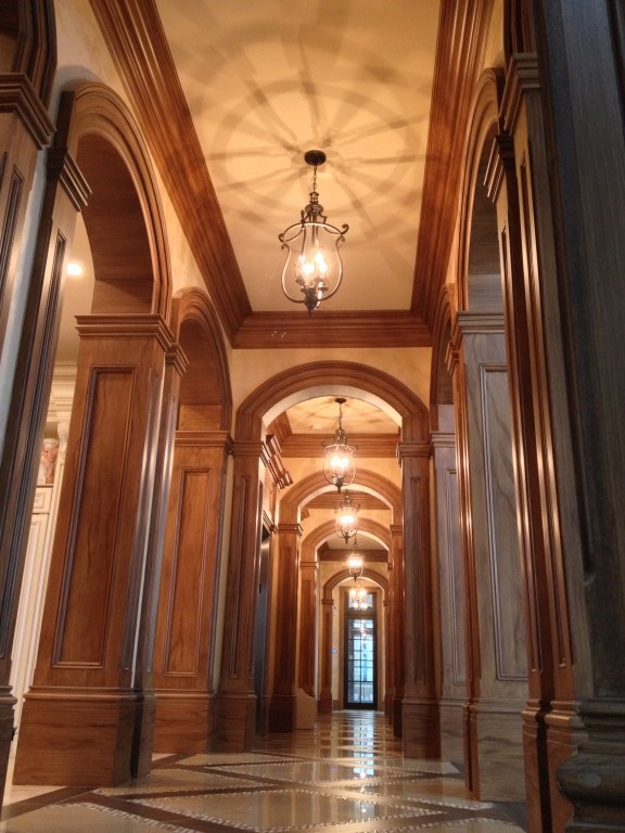 На фото: огромный коридор в викторианском стиле с белыми стенами, полом из керамогранита и разноцветным полом с
