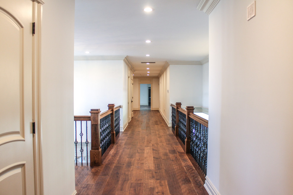 Idées déco pour un couloir classique de taille moyenne avec un sol en bois brun et un mur blanc.