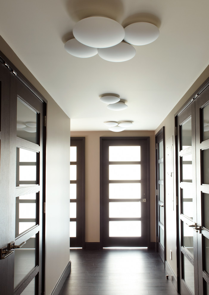 Foto de recibidores y pasillos actuales de tamaño medio con paredes beige y suelo de madera oscura