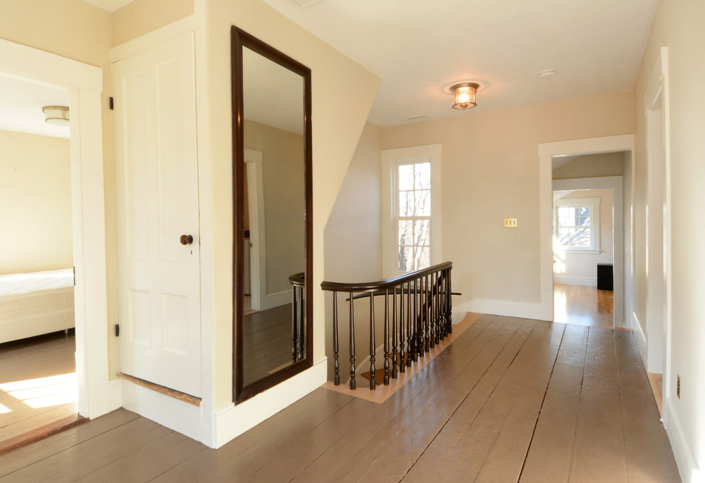 На фото: большой коридор в классическом стиле с белыми стенами и деревянным полом