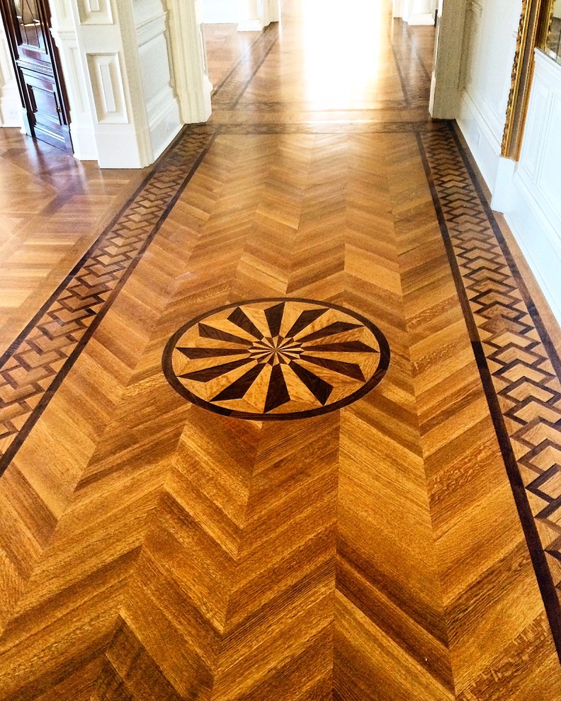 Aménagement d'un très grand couloir classique avec un mur beige et parquet foncé.