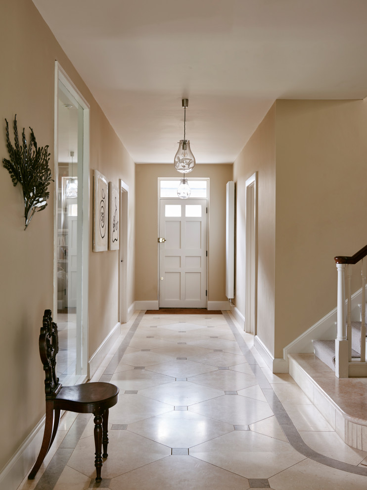 Esempio di un grande ingresso o corridoio classico con pareti beige, pavimento in pietra calcarea e pavimento multicolore