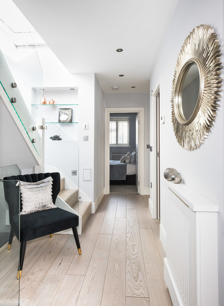 Exemple d'un couloir chic de taille moyenne avec un mur gris, parquet clair et un sol beige.