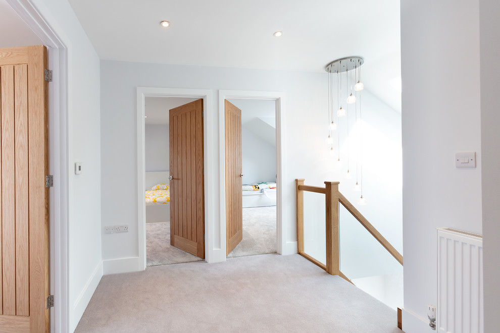 Idée de décoration pour un couloir minimaliste de taille moyenne avec un mur gris, moquette et un sol gris.