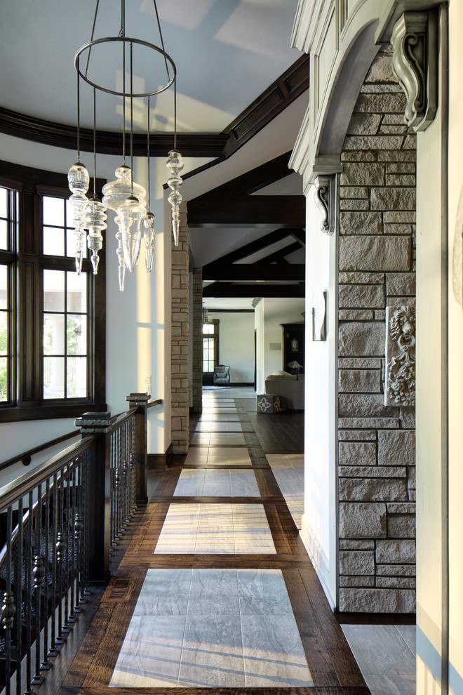 Réalisation d'un grand couloir design avec un mur gris et un sol en bois brun.