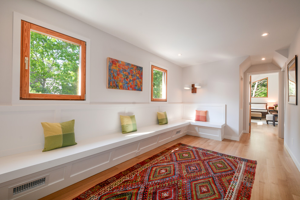 Moderner Flur mit weißer Wandfarbe und braunem Holzboden in New York