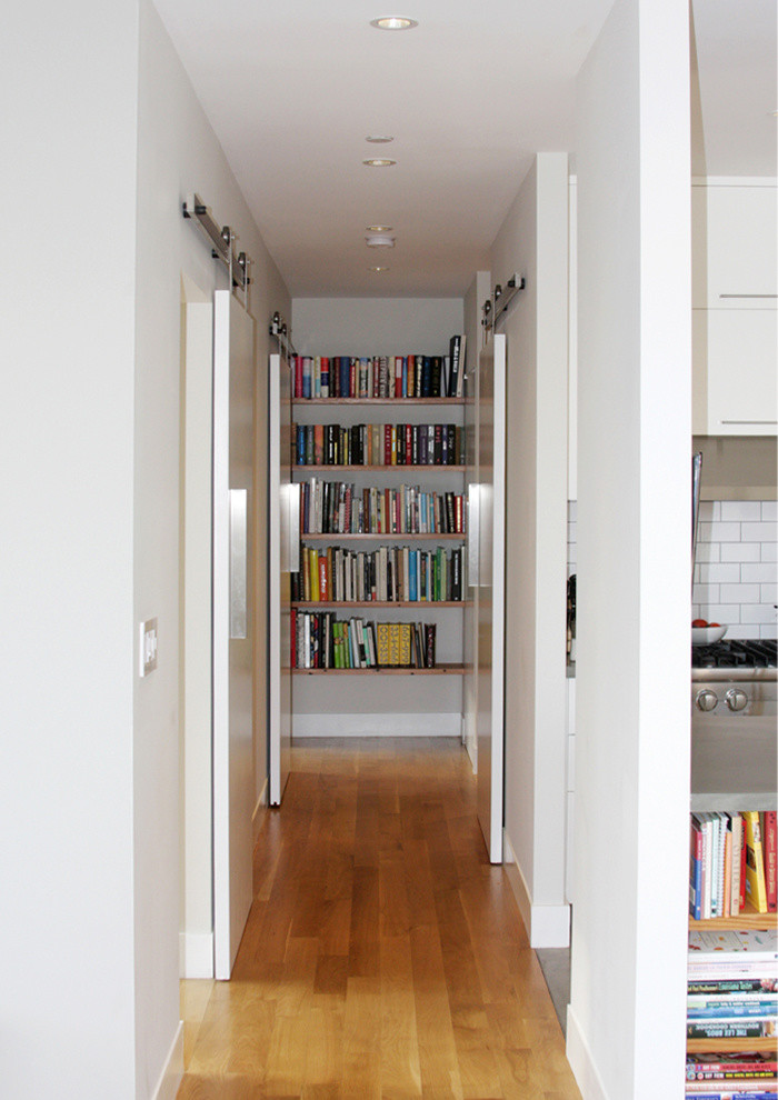 Cette photo montre un petit couloir tendance avec un mur blanc et parquet clair.
