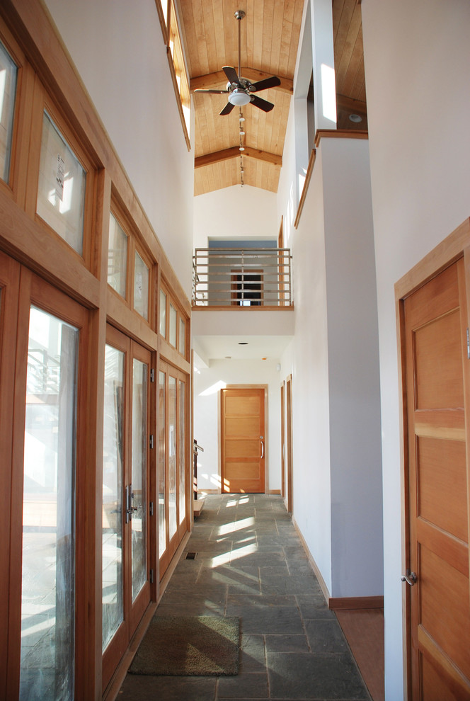 Modelo de recibidores y pasillos contemporáneos grandes con paredes blancas y suelo de pizarra