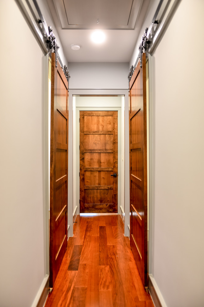 Стильный дизайн: большой коридор в современном стиле с серыми стенами, паркетным полом среднего тона и коричневым полом - последний тренд