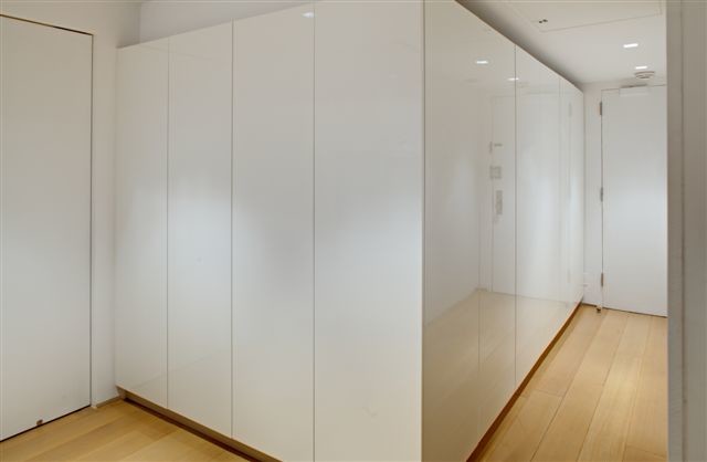Foto de recibidores y pasillos minimalistas pequeños con paredes blancas, suelo laminado y suelo beige