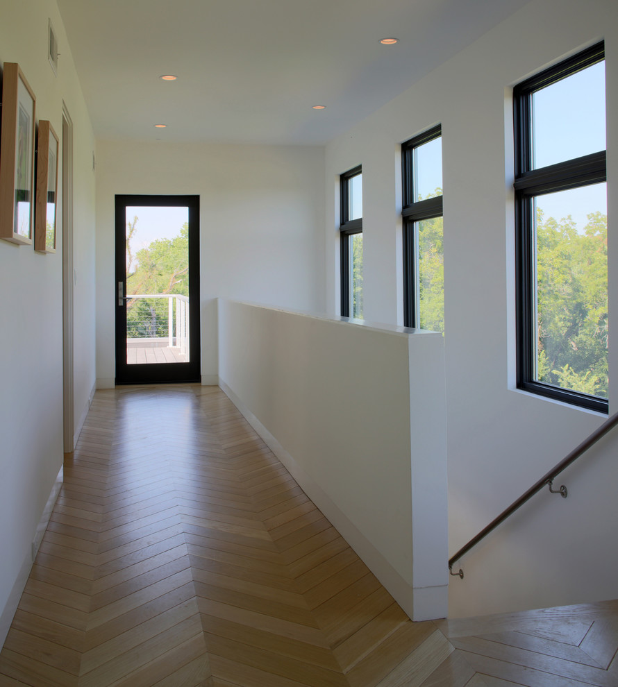Idée de décoration pour un couloir design de taille moyenne avec un mur blanc, un sol en bois brun et un sol marron.