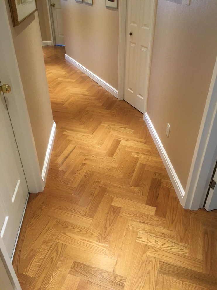 Inspiration for a small timeless medium tone wood floor and brown floor hallway remodel in Montreal with beige walls